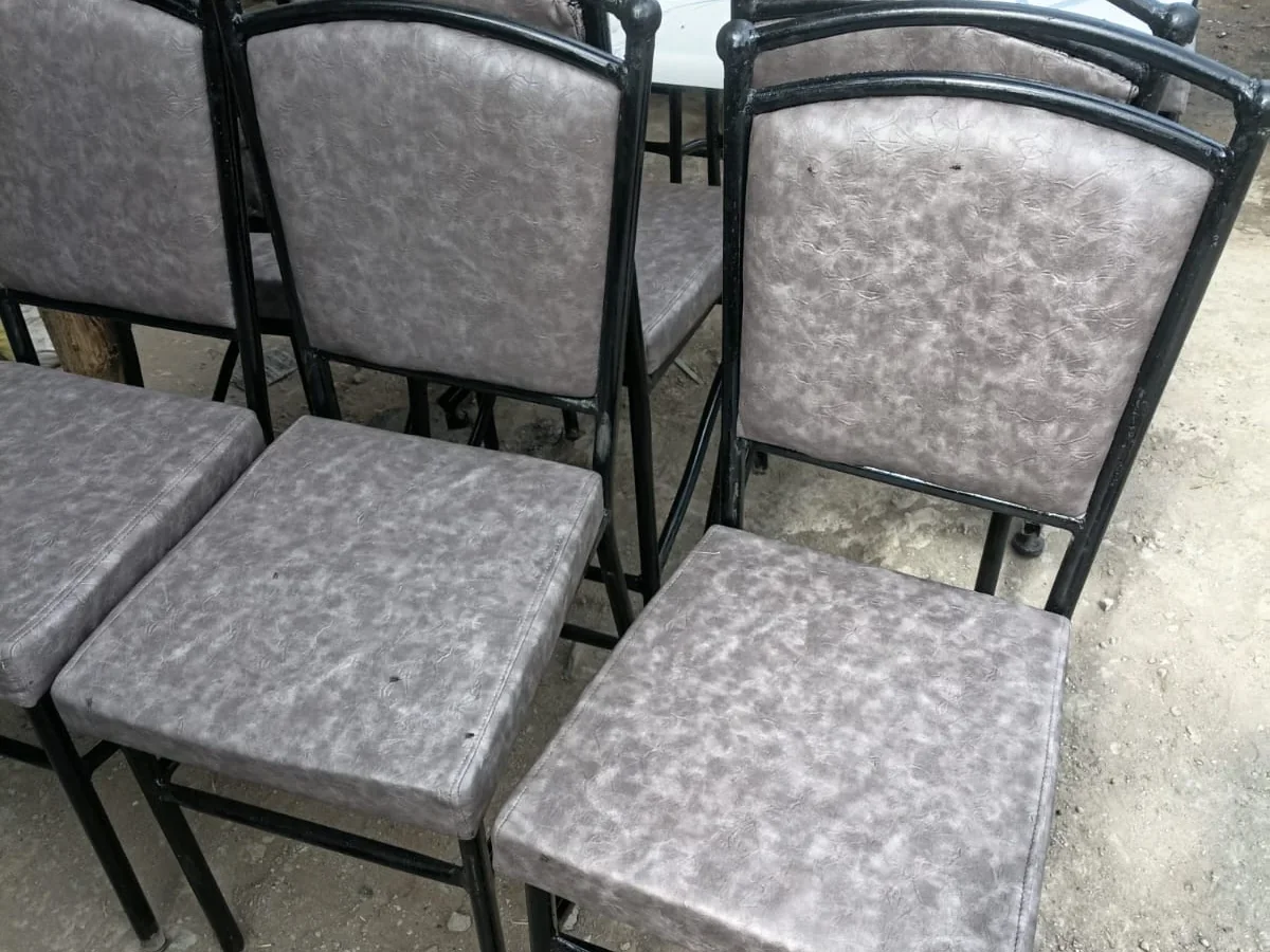 High-back chairs with black steel frames and gray vinyl upholstery around a rectangular table.