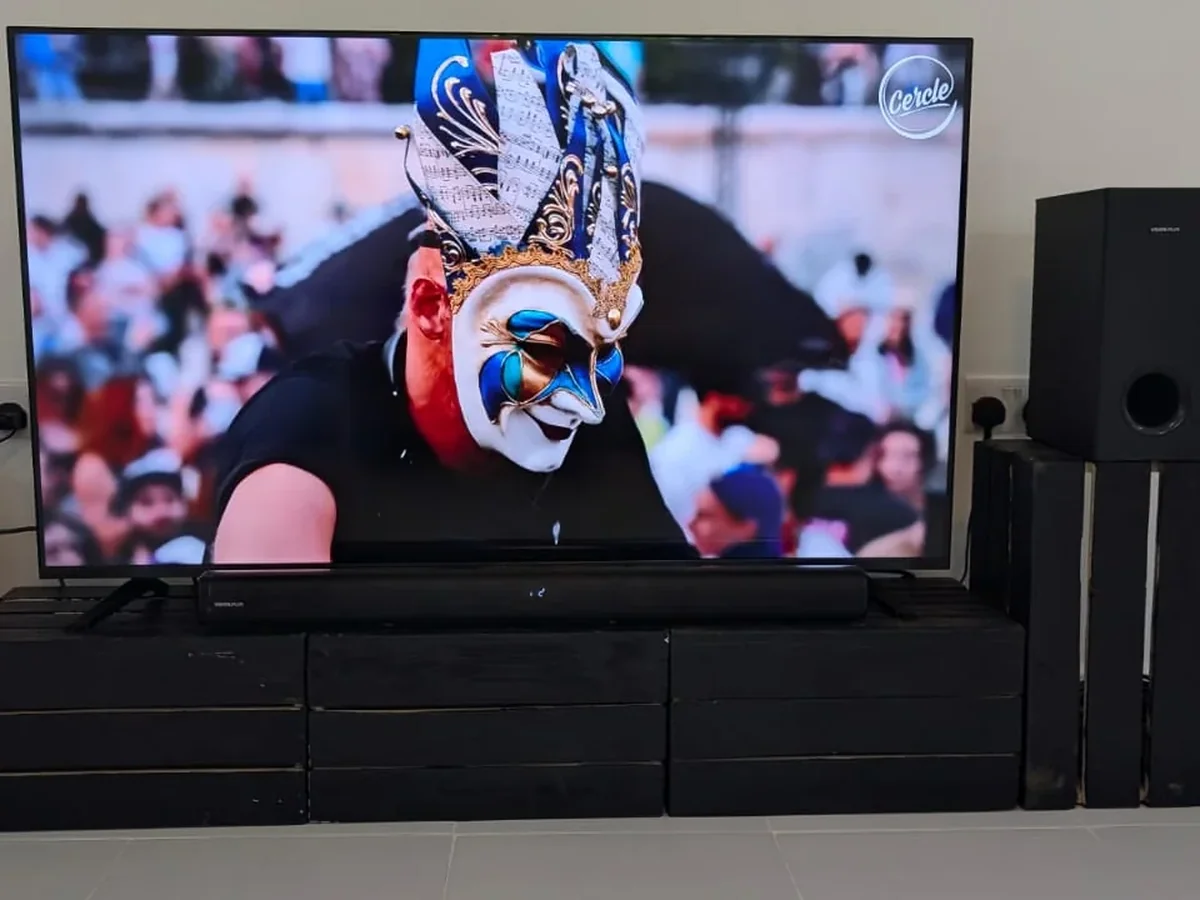 Front view of a modular crate-wood TV console with a flat-screen TV.